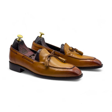 Pair of brown leather loafers with tassels on a white background