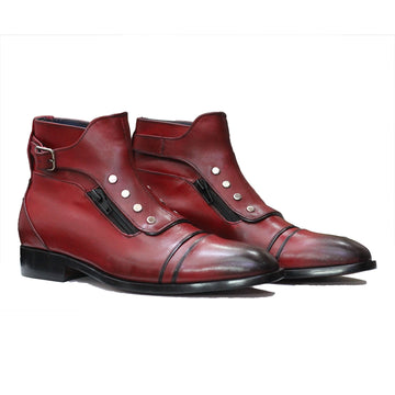 Pair of red leather boots with decorative elements on a white background