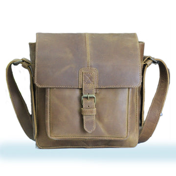 Brown leather satchel bag on a light blue background
