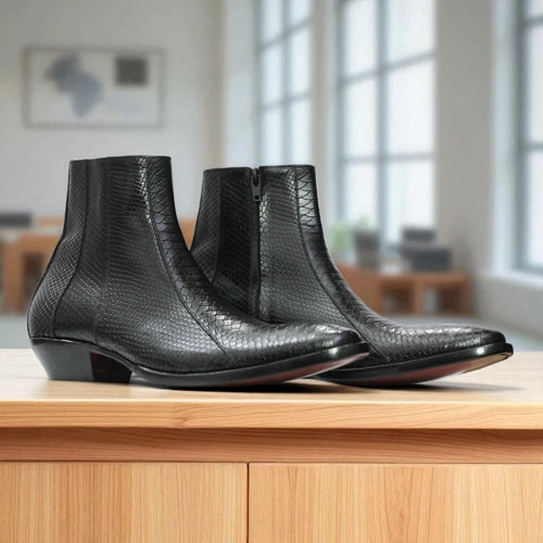 Three black leather boots on a wooden surface with a blurred indoor background