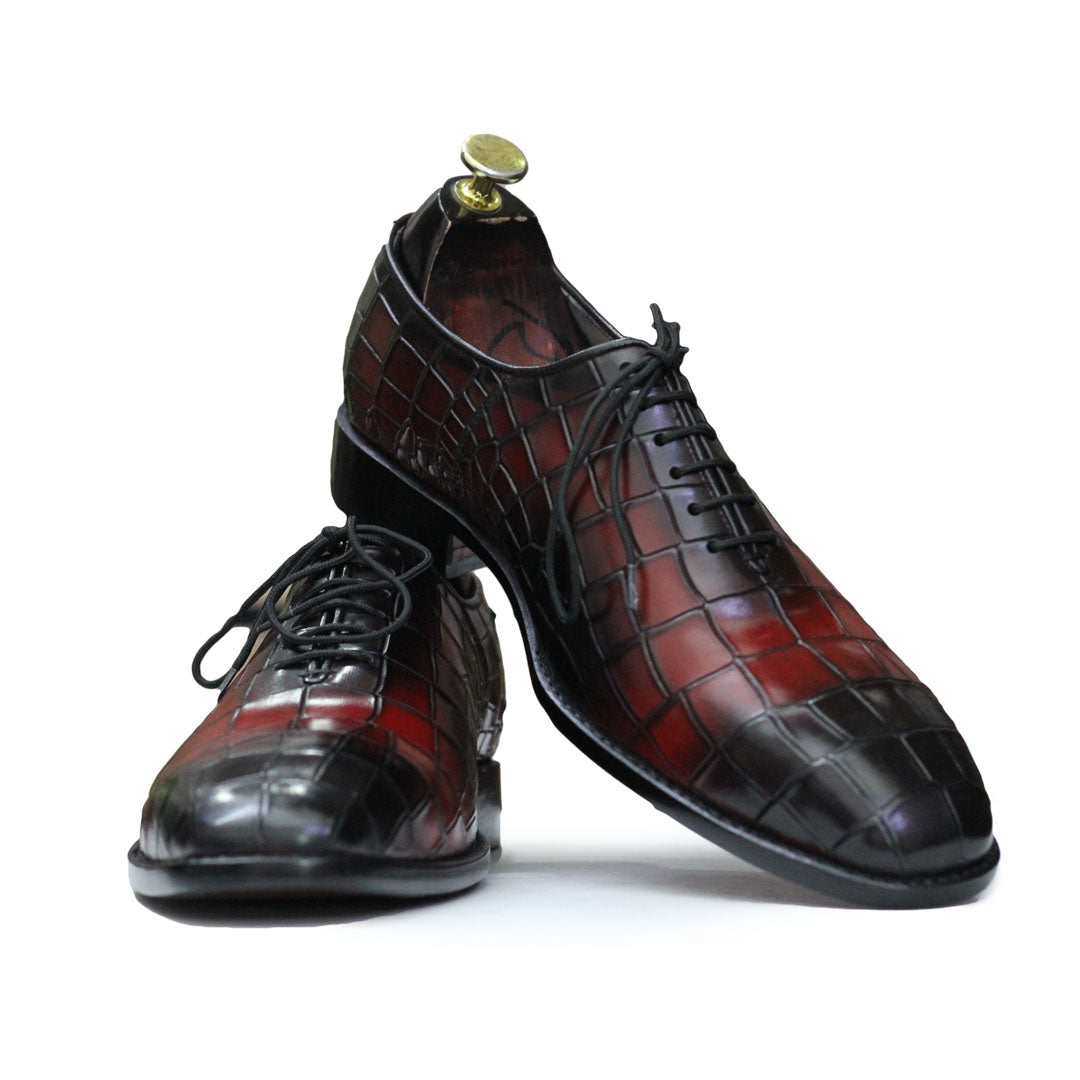 Pair of black and red leather shoes on a white background