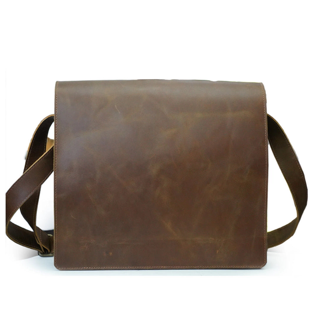 Brown leather bag with strap on a white background