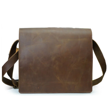 Brown leather bag with strap on a white background