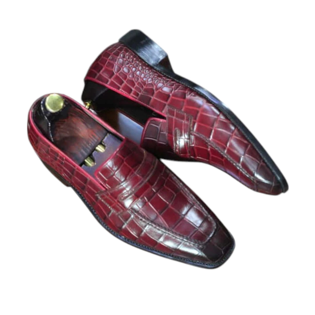 Pair of red leather shoes with a textured pattern on a white background