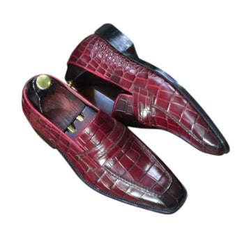 Pair of red leather shoes with a textured pattern on a white background