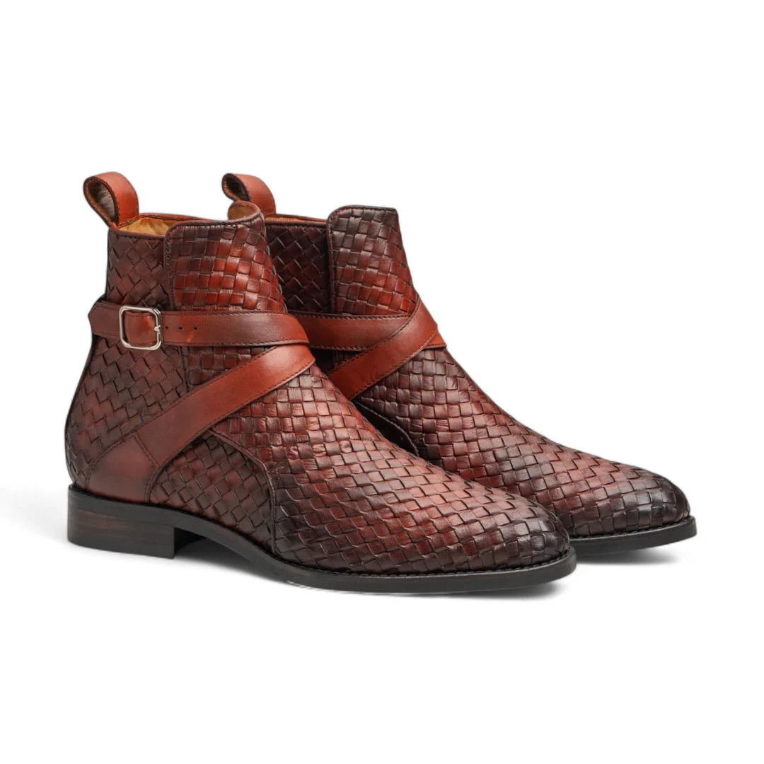 Pair of brown woven leather boots with a strap on a white background