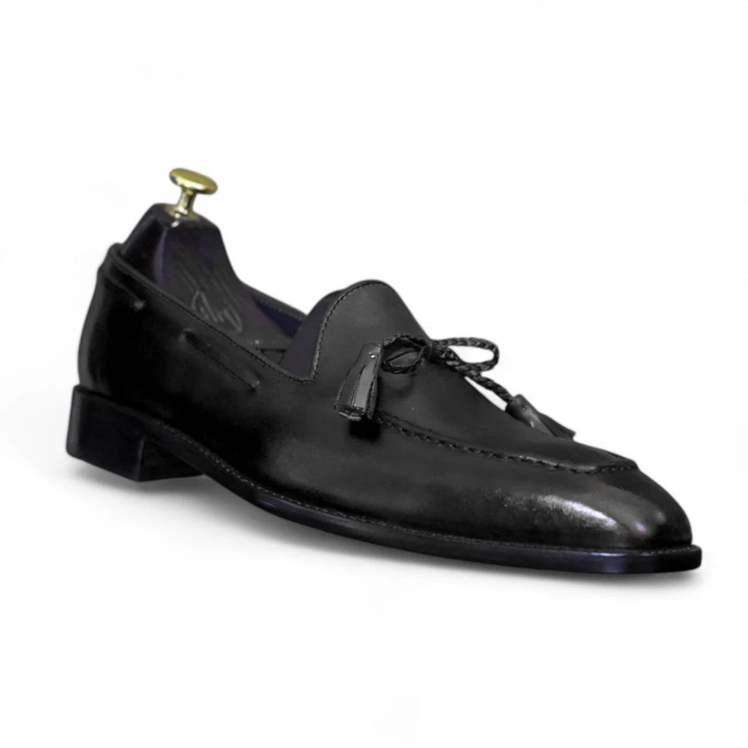Black leather loafer with tassel on a white background