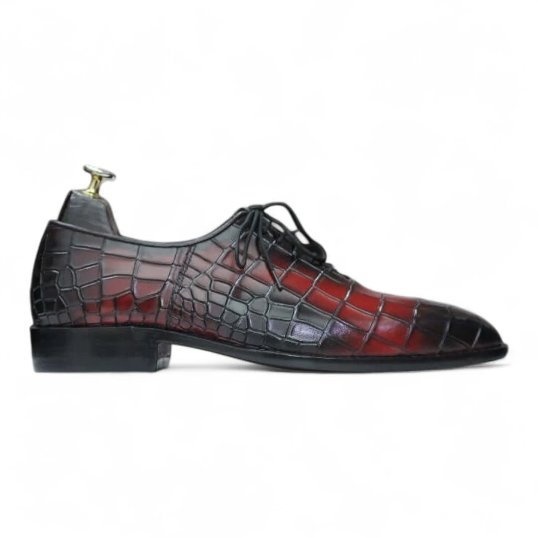 Black and red crocodile-patterned dress shoes on a white background