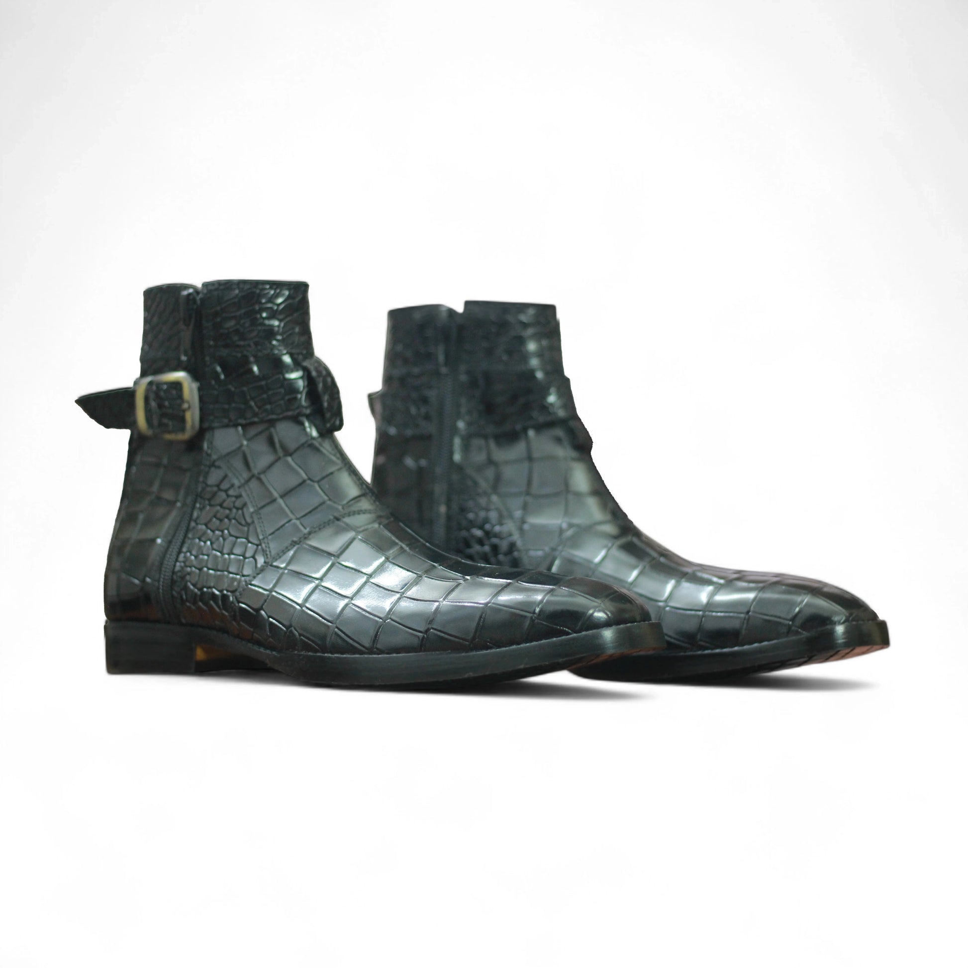 Pair of green crocodile skin boots on a white background