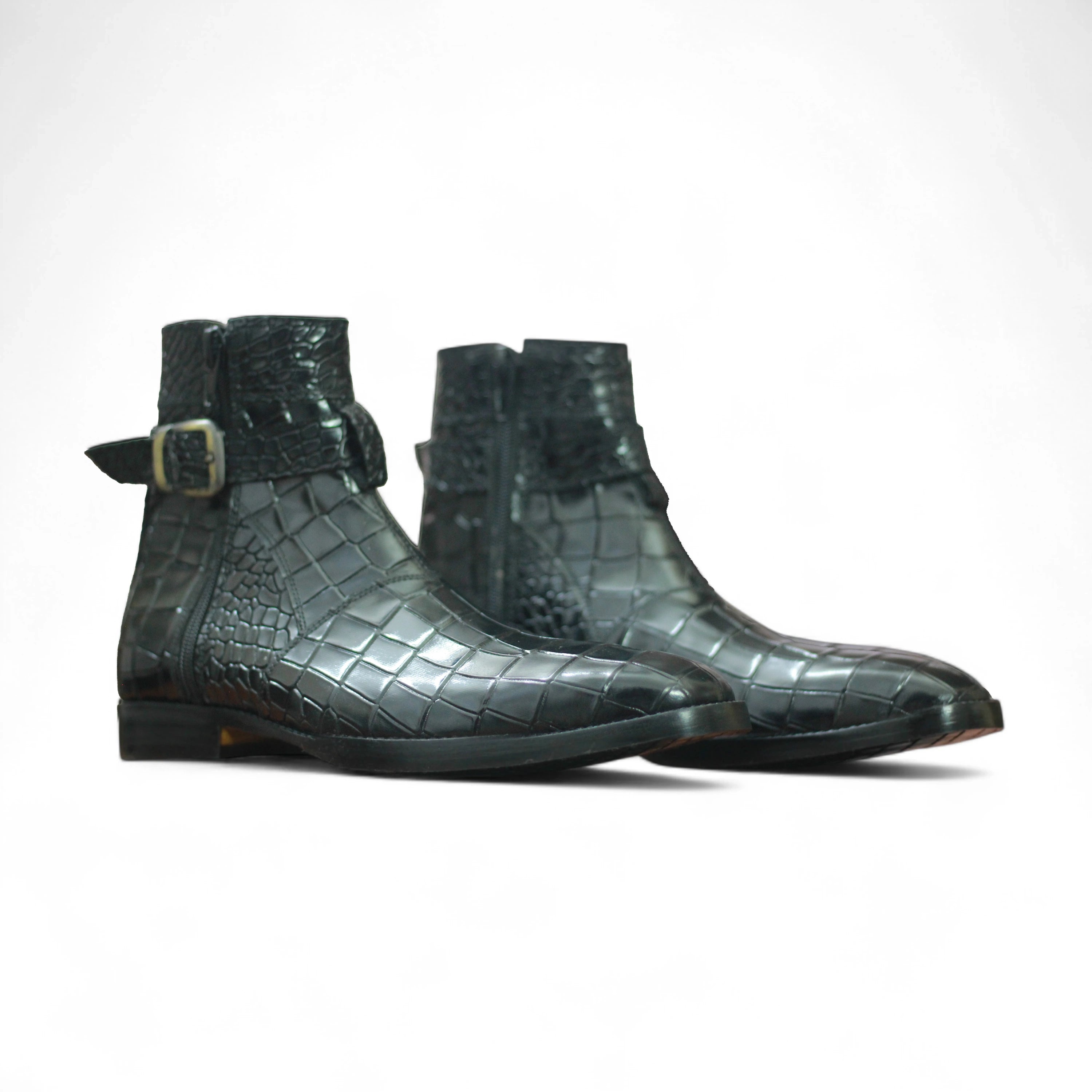 Pair of green crocodile skin boots on a white background