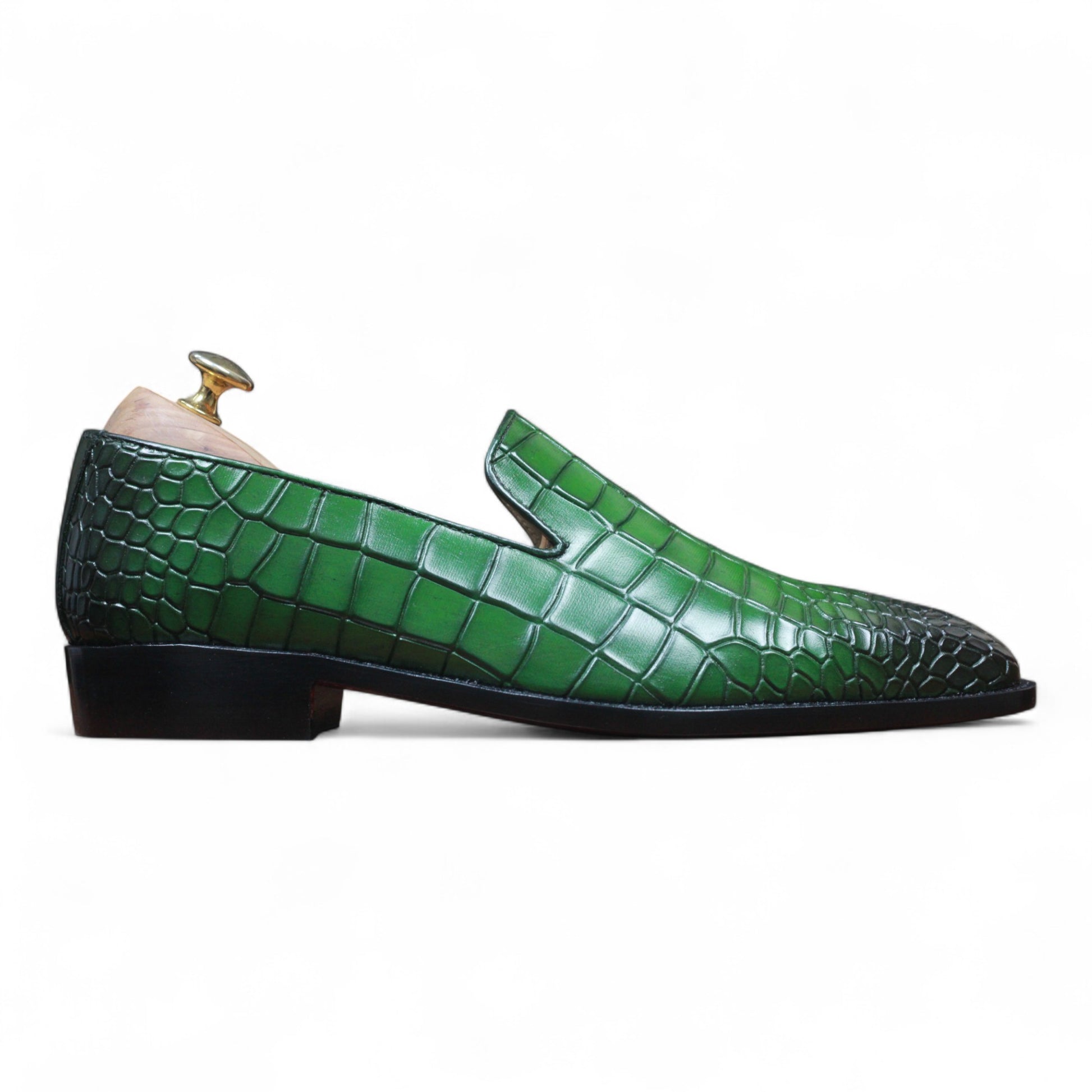 Close-up of green alligator leather texture on loafer

