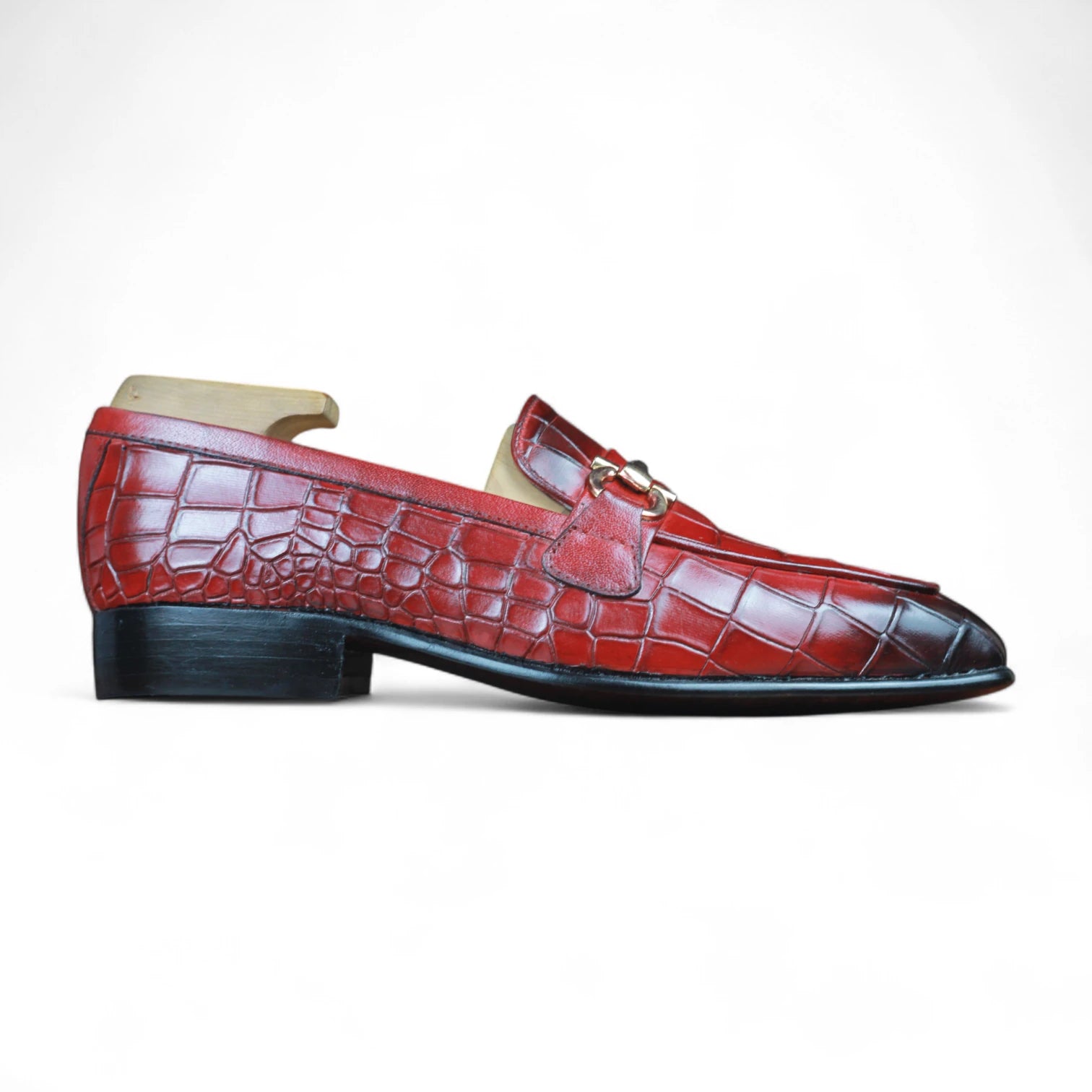 Red crocodile-patterned loafer shoe on a white background