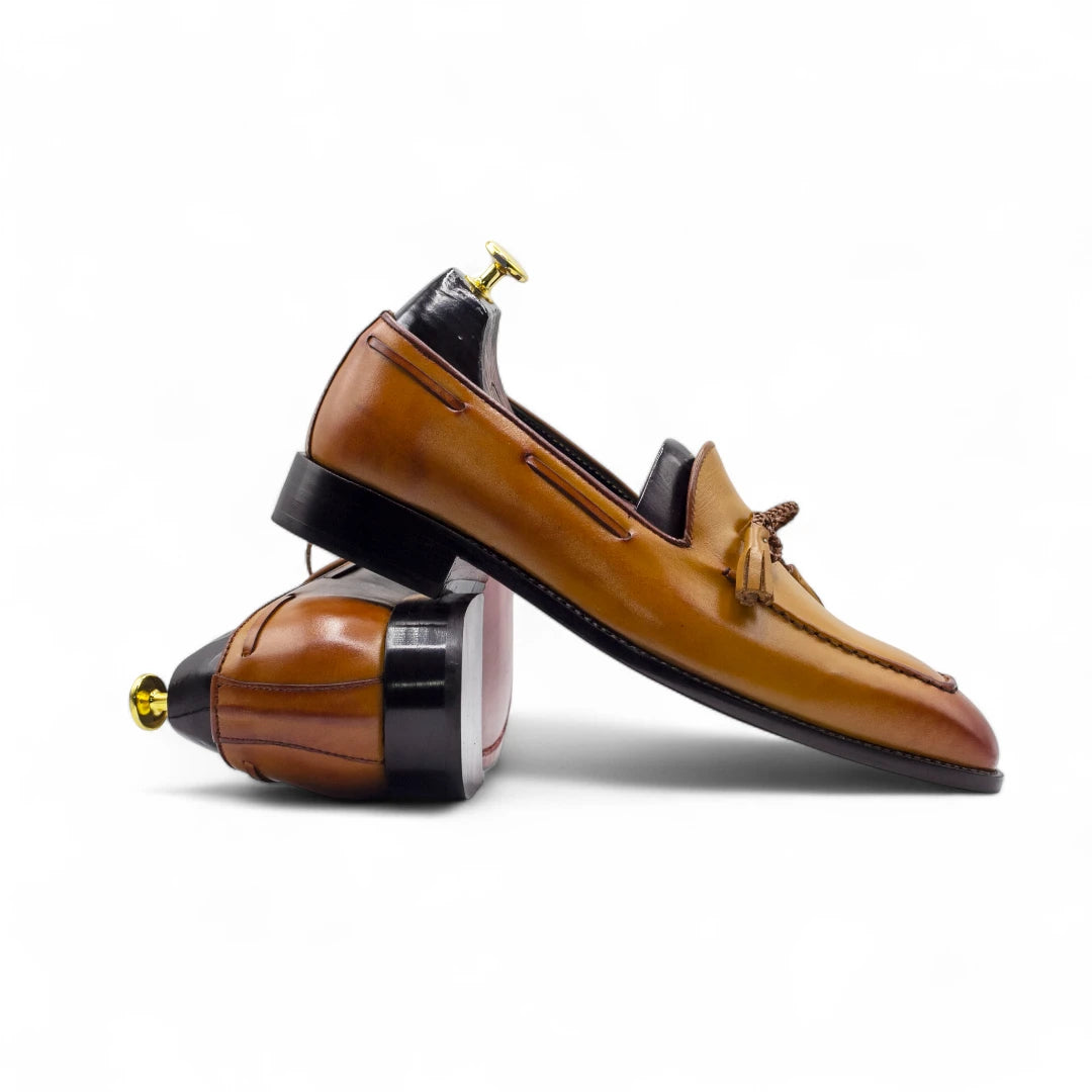 Brown leather loafer with wooden sole on a white background