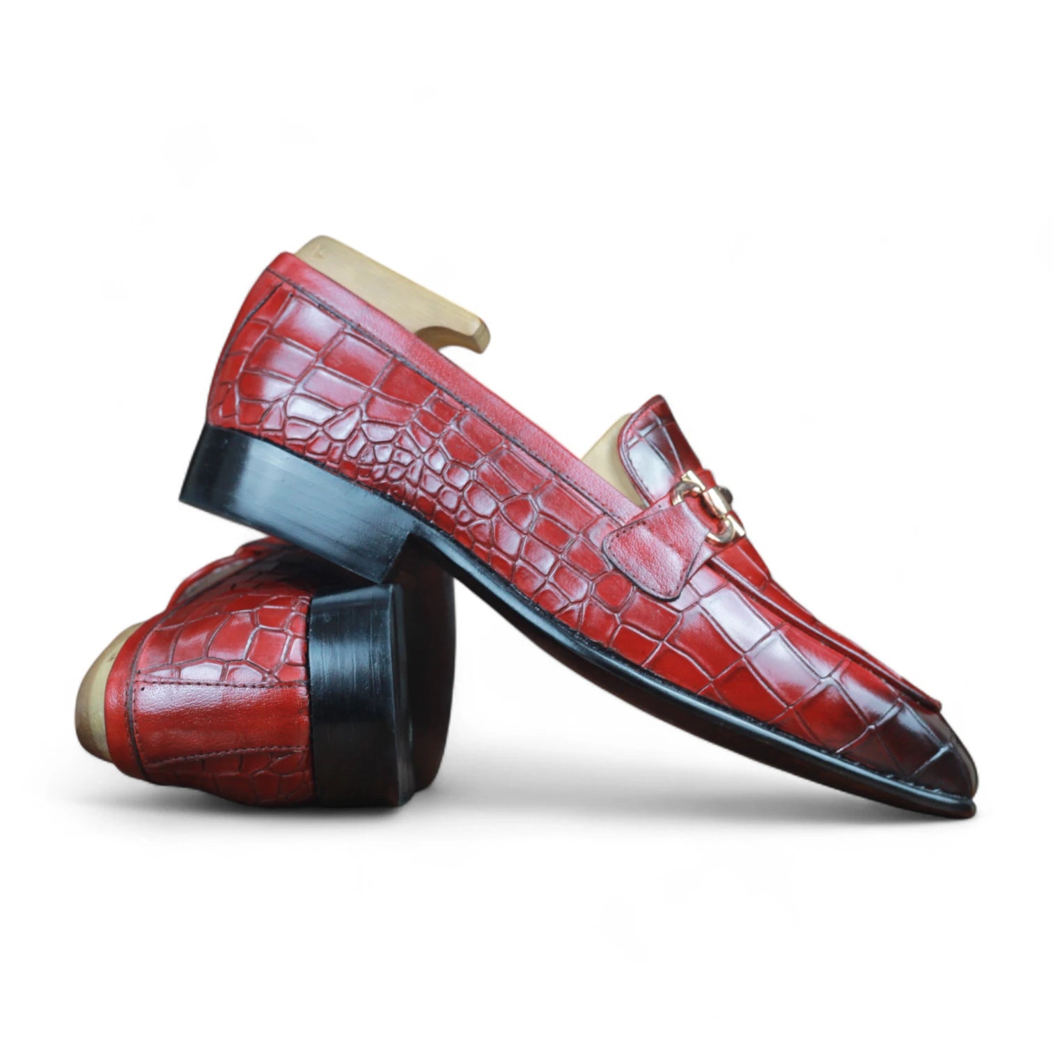 Red leather loafers with a textured pattern on a white background