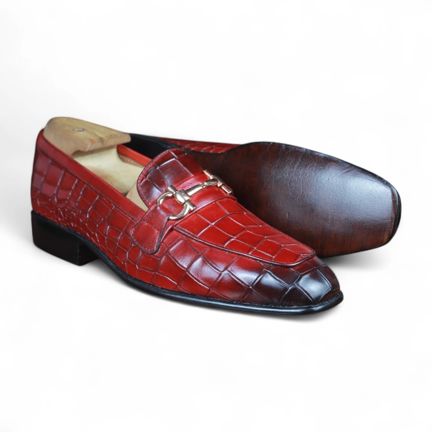 Pair of red and brown leather loafers on a white background