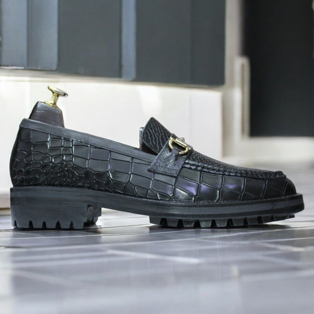 Black Alligator Loafer Shoes displayed on a wooden surface, showcasing their sleek design and elegant texture.