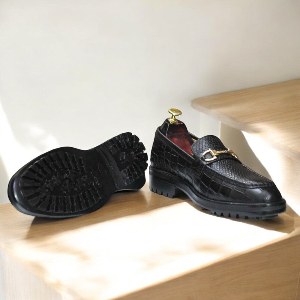 Black Alligator Loafer Shoes displayed on a wooden surface, showcasing their sleek design and elegant texture.
