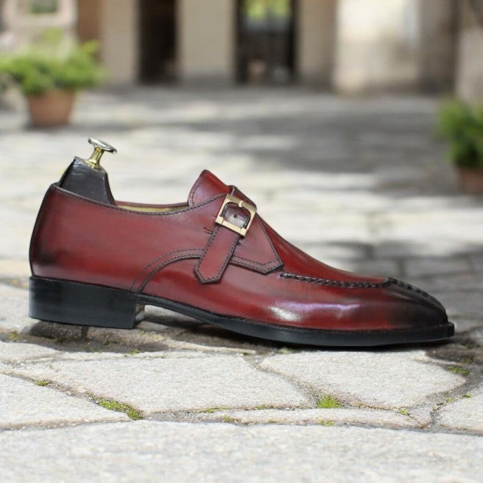 Handmade men's burgundy Oxford dress shoes, featuring a premium leather upper, a split-toe design, and a single buckle monk strap, displayed on a sleek leather sole
