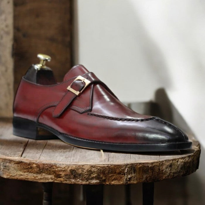 Handmade men's burgundy Oxford dress shoes, featuring a premium leather upper, a split-toe design, and a single buckle monk strap, displayed on a sleek leather sole