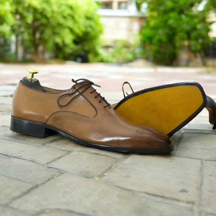 Men's tan whole cut leather lace-up shoes on a white background.