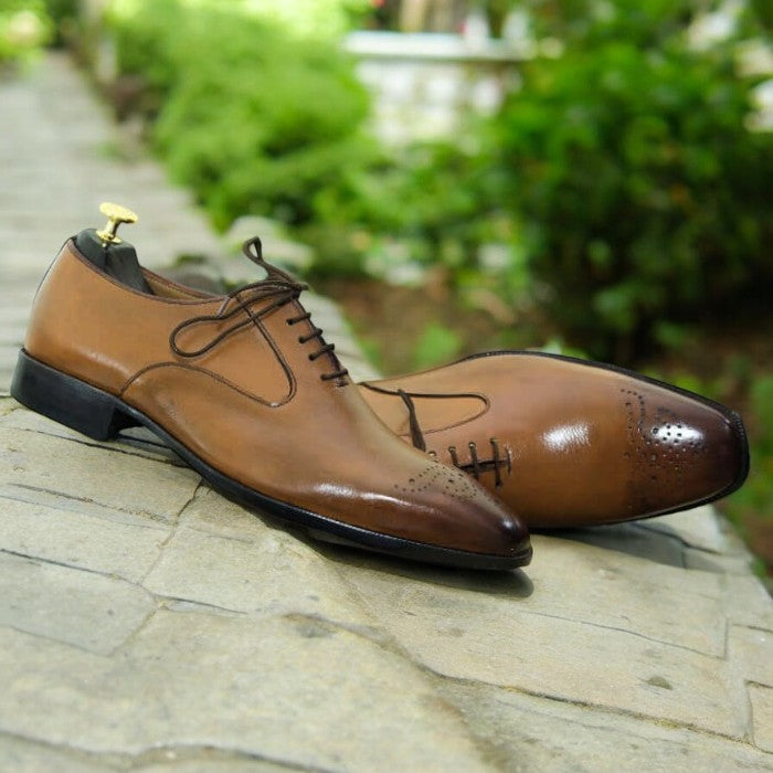 Men's tan whole cut leather lace-up shoes on a white background.