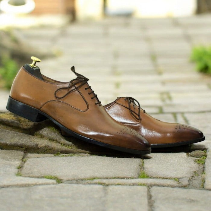 Men's tan whole cut leather lace-up shoes on a white background.