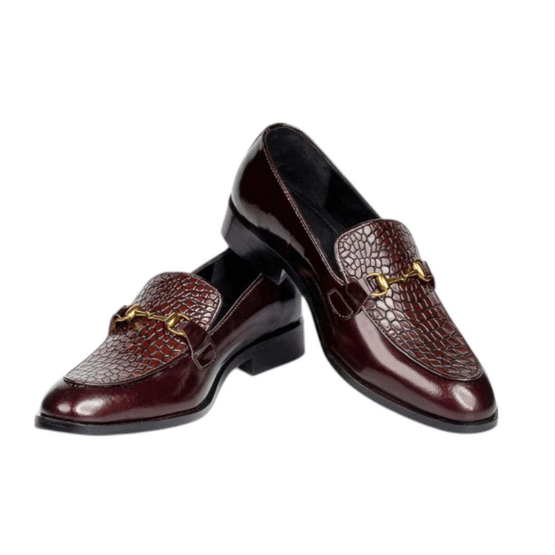 Pair of brown leather loafers with gold accents on a white background