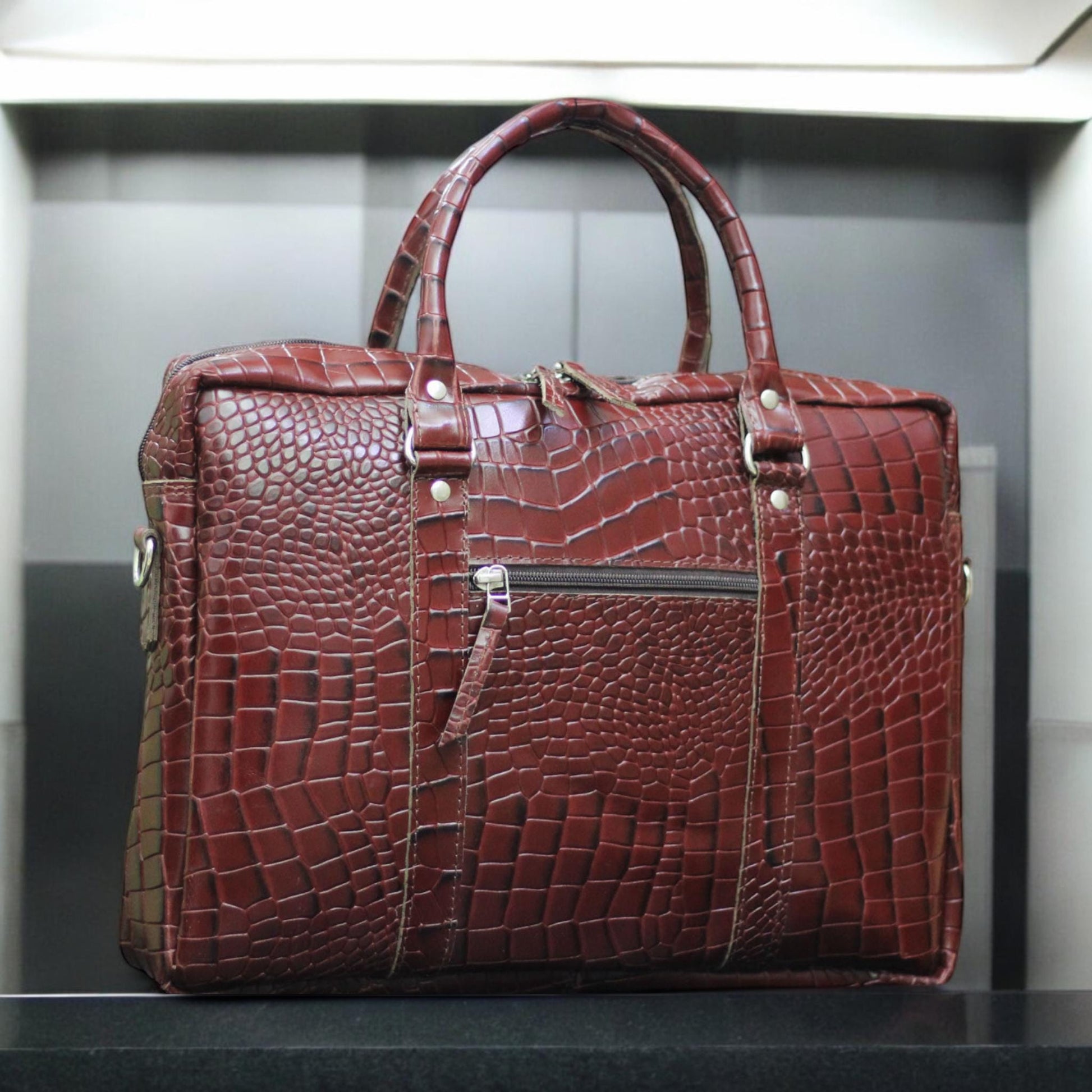 Front View – Elegant alligator-textured leather laptop bag with flap closure and sleek silhouette.

