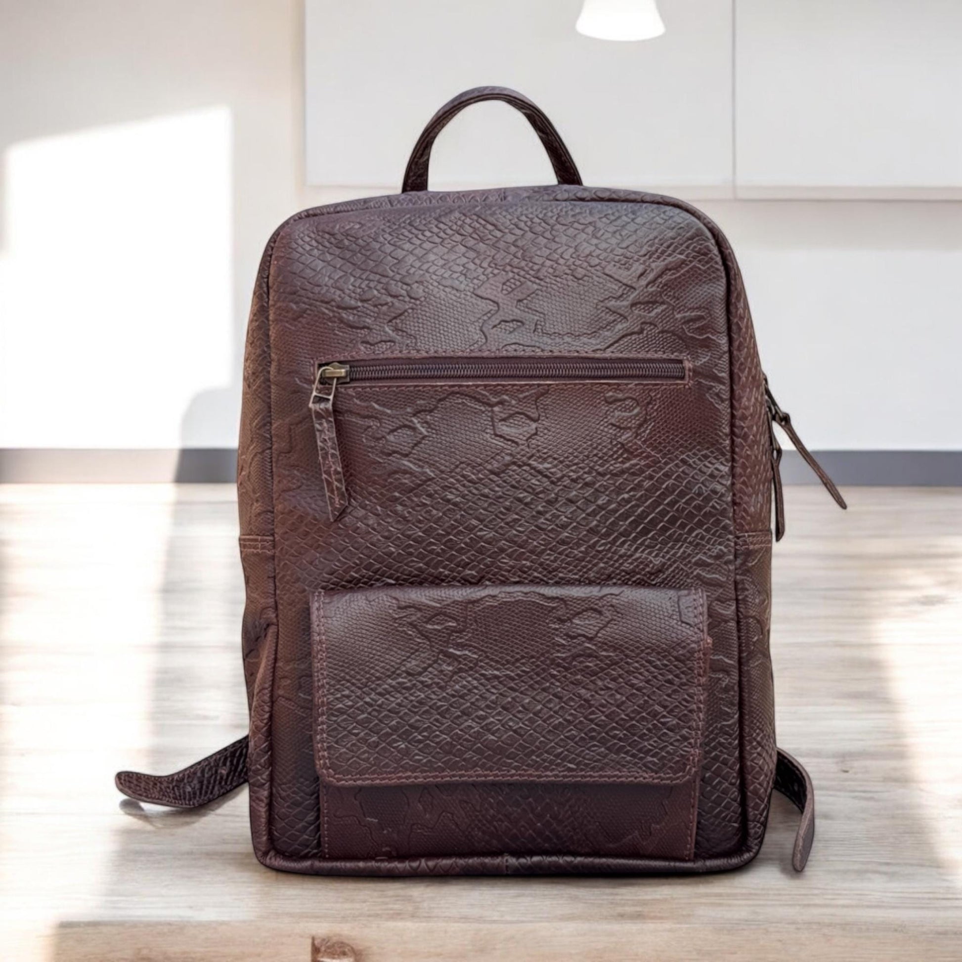 Front View – Python-embossed leather backpack with a zippered front pocket and sleek silhouette.

